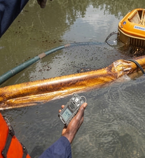 Responder testing water beside a skimmer and boom